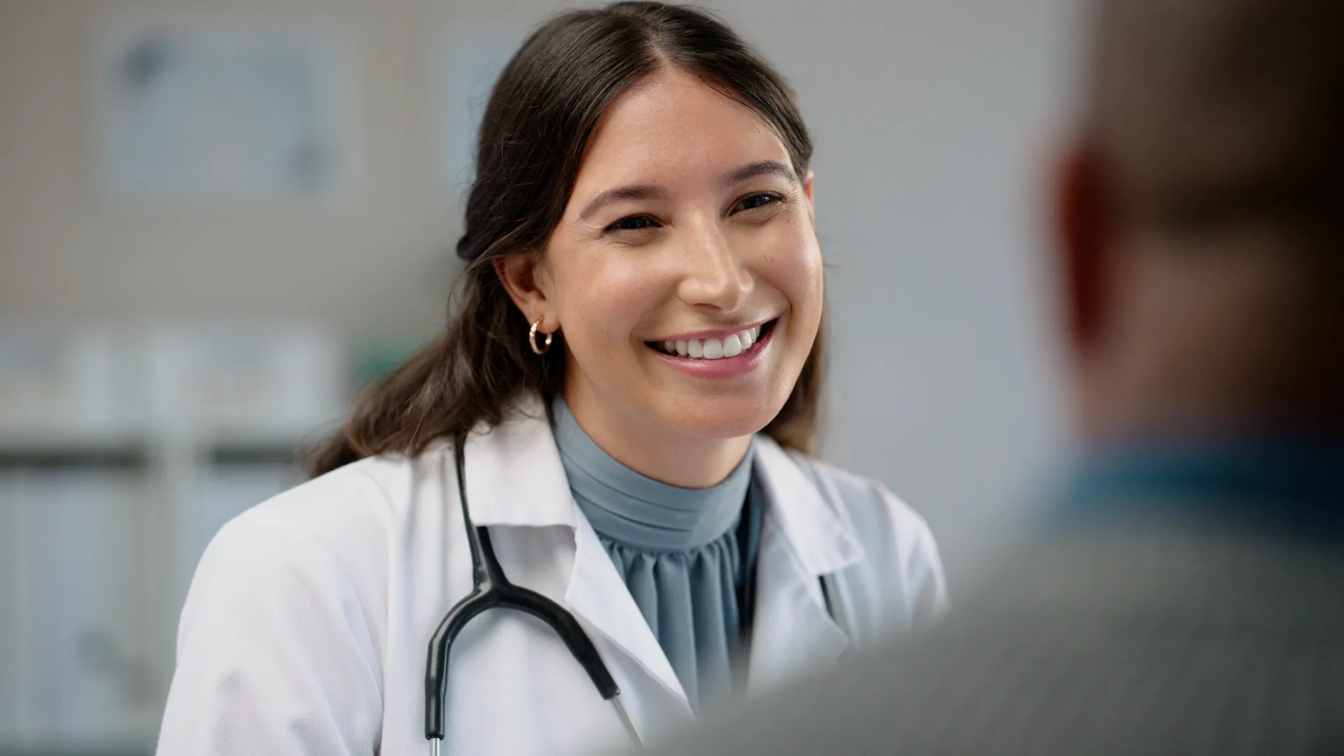 Compassionate healthcare professional warmly greeting a patient at a treatment facility