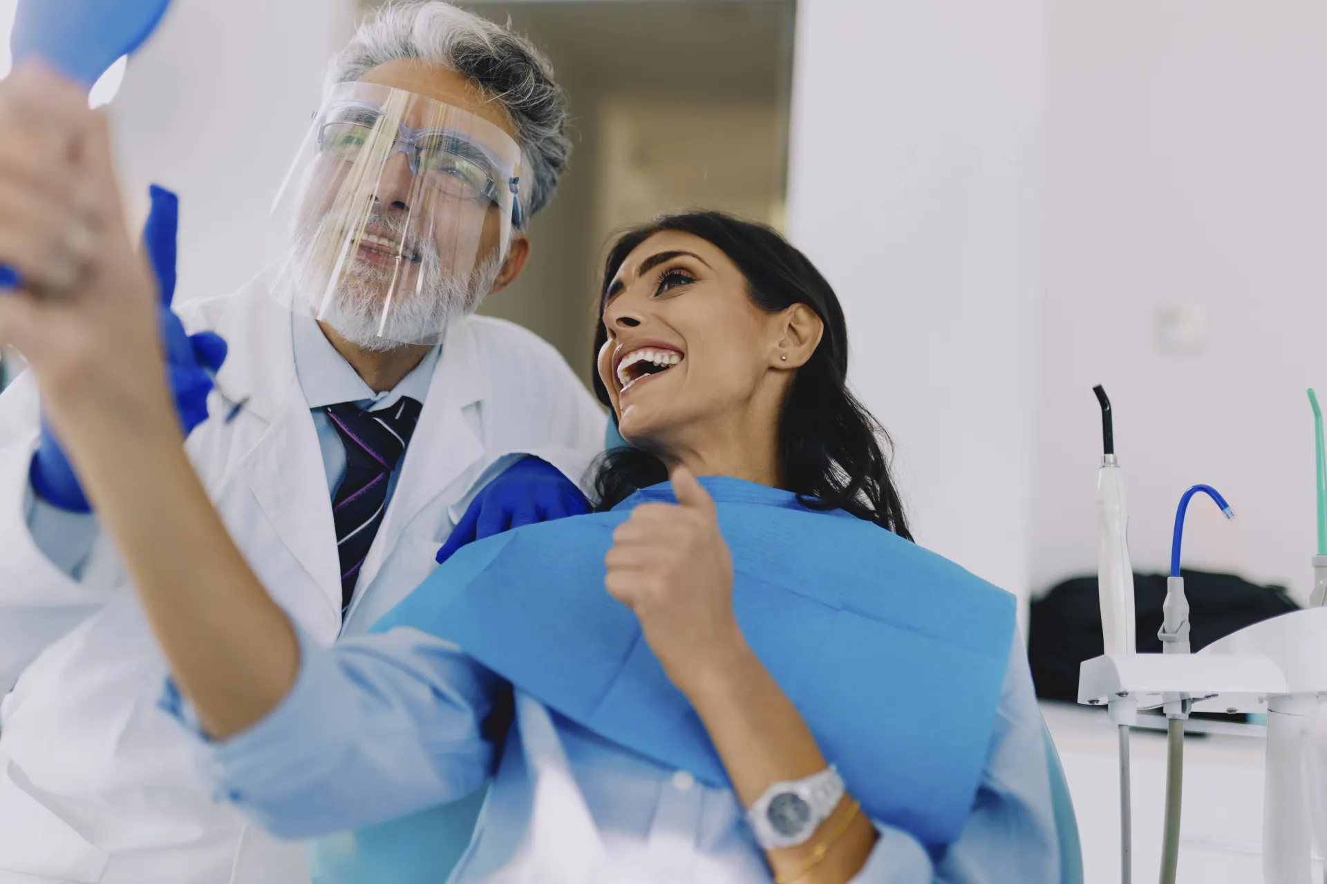 Delighted patient giving a thumbs up after a successful dental procedure